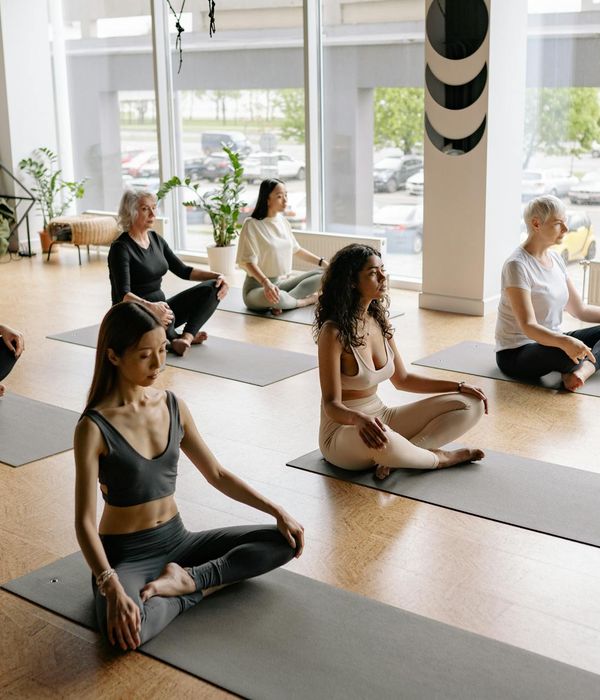 Diverse group of people of different ages sitting on yoga mats.